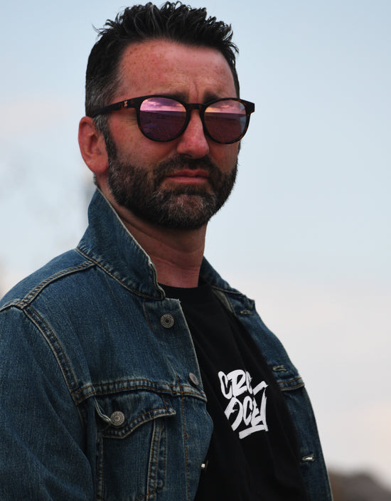 Man with glasses and denim jacket.